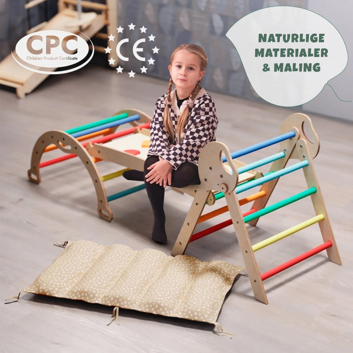 Regnbue klatrebue med beige pute som vippe – Montessori-lek for barn 1–3 år